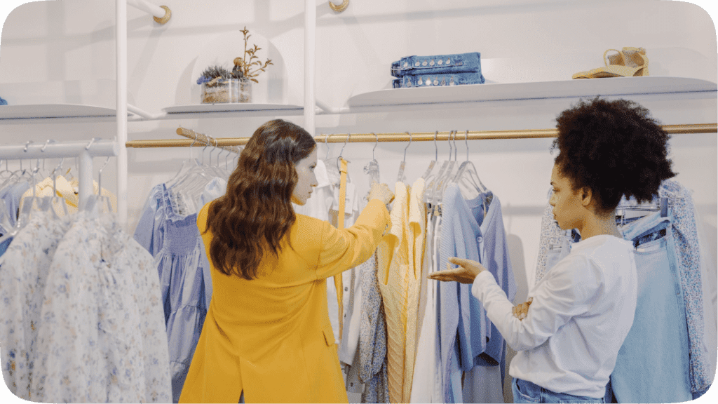 Two women choosing shirts at a clothes store